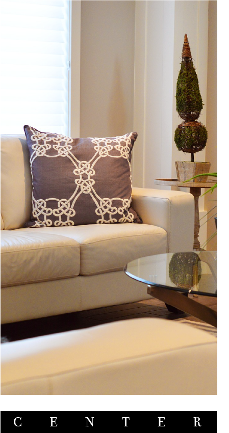 sala con moviliario color blanco y un cojin color morado y blanco