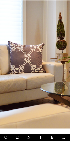 sala con moviliario color blanco y un cojin color morado y blanco